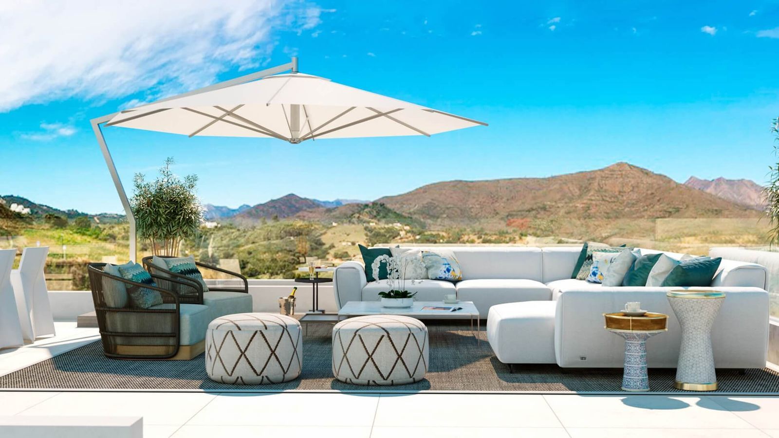 Terrasse de luxe avec canapé d'angle blanc, fauteuils et vue imprenable sur la montagne.